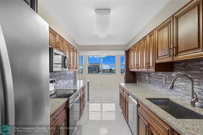 a kitchen with stainless steel appliances granite countertop a sink stove and cabinets