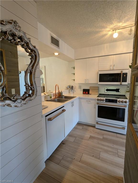 a kitchen with sink a microwave and cabinets