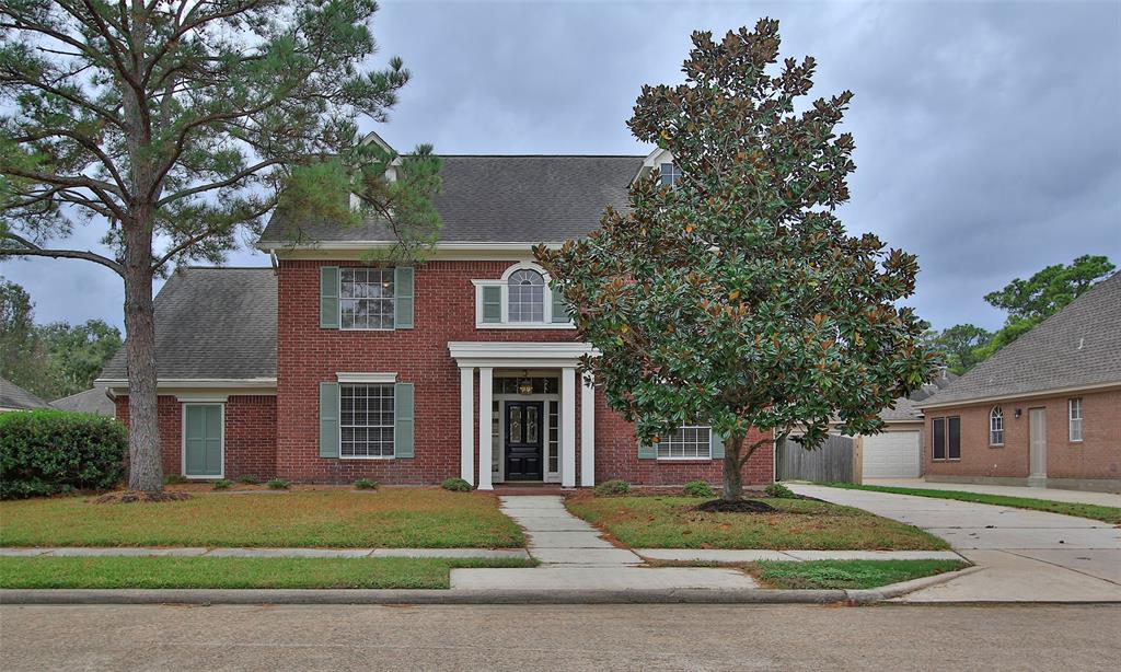 a front view of a house with a yard and trees