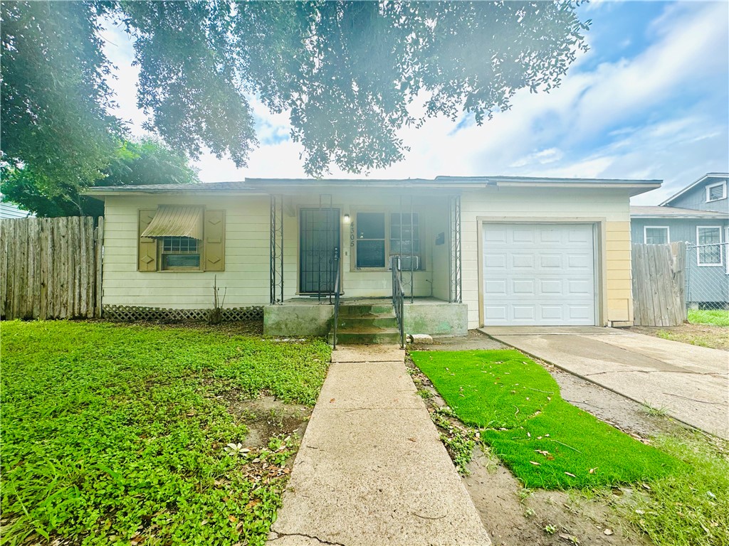 front view of a house with a yard and potted plants