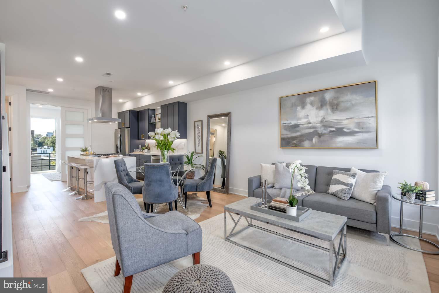 a living room with furniture and a view of kitchen