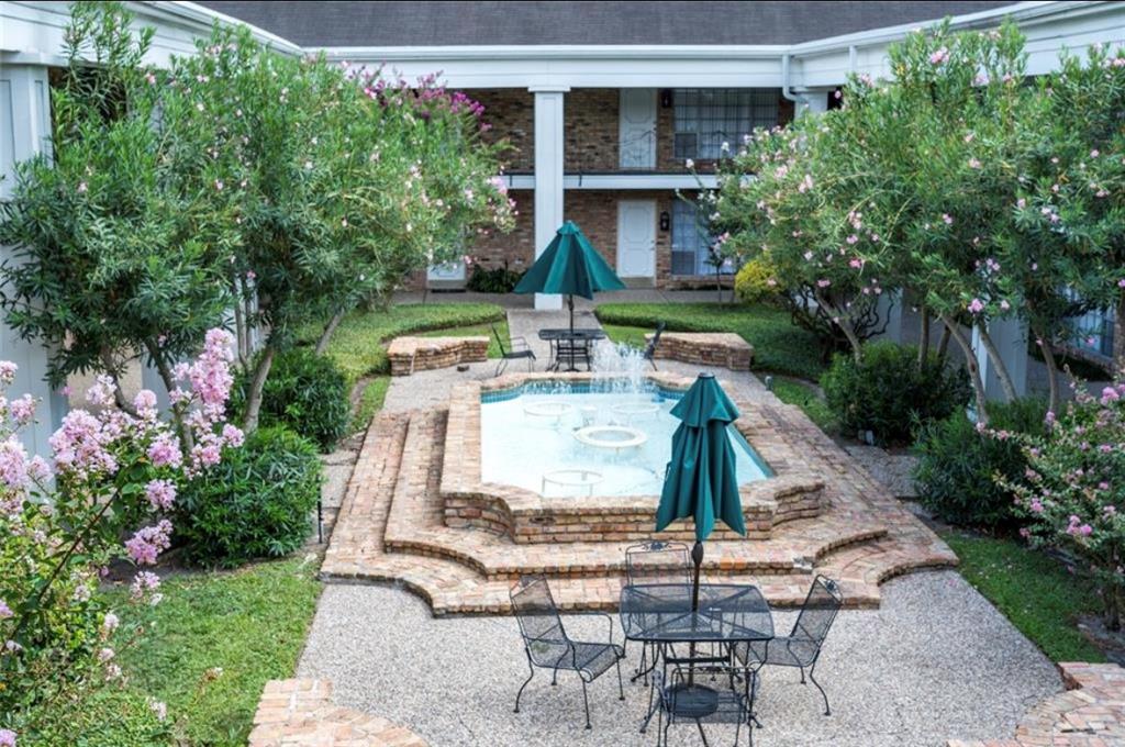 a view of a patio with table and chairs potted plants and large tree