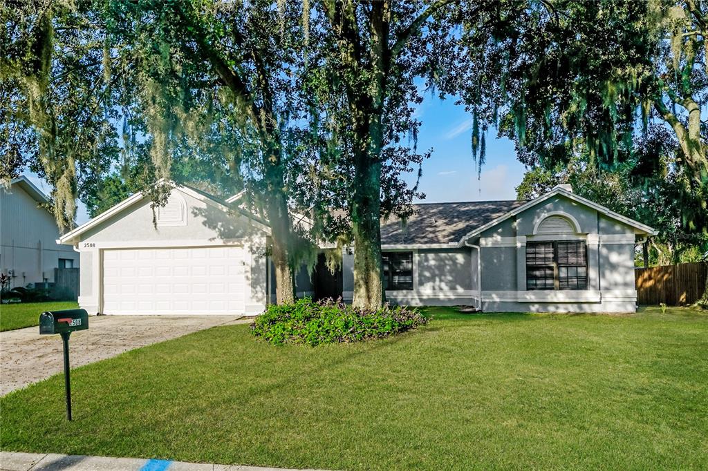 a front view of a house with a garden and yard