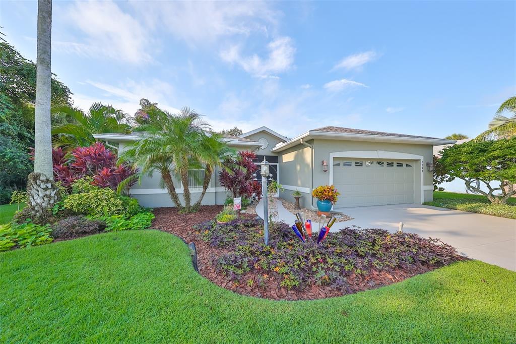 Front view w/ beautiful tropical landscaping.