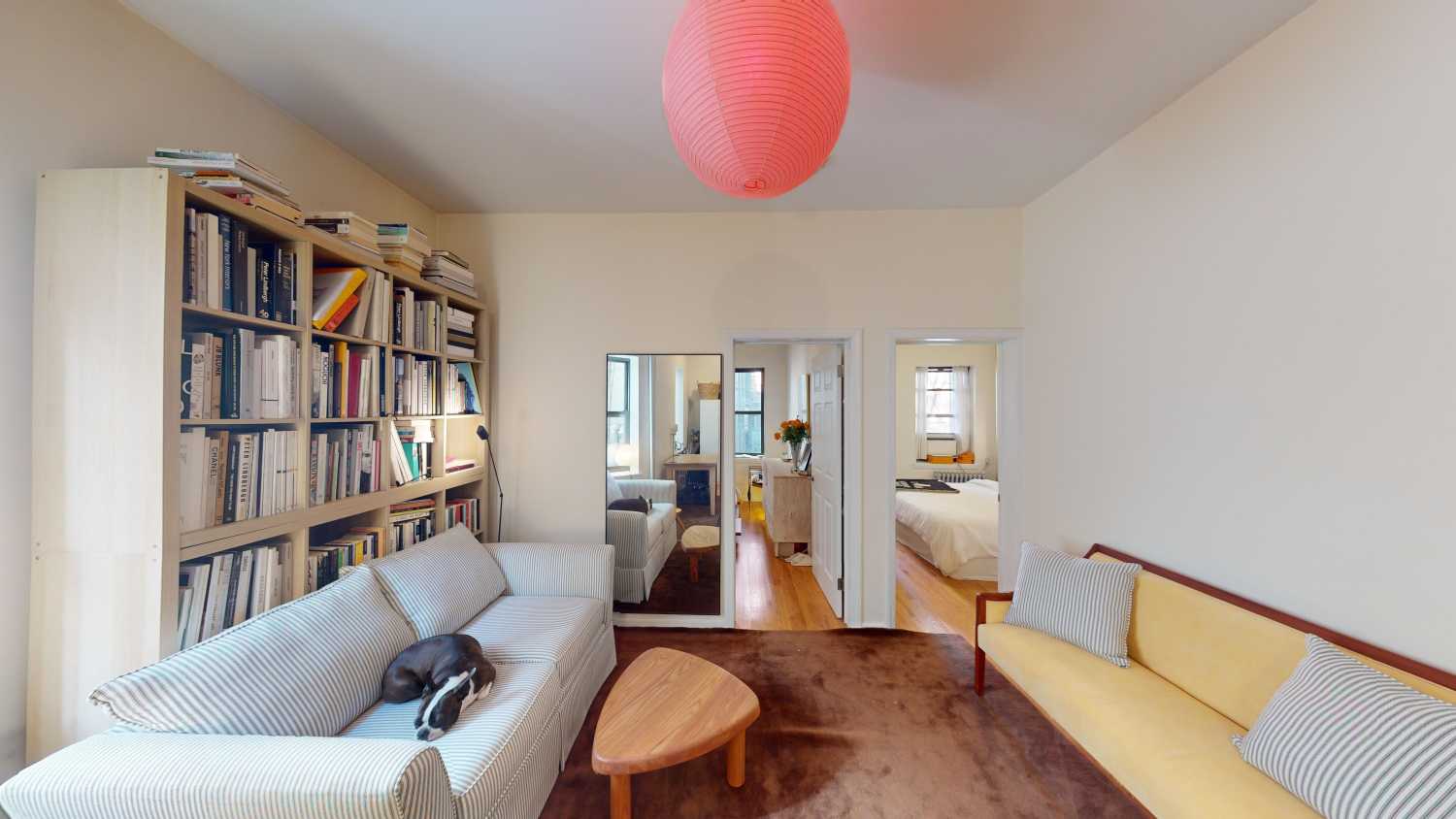 a living room with furniture a rug and a book shelf