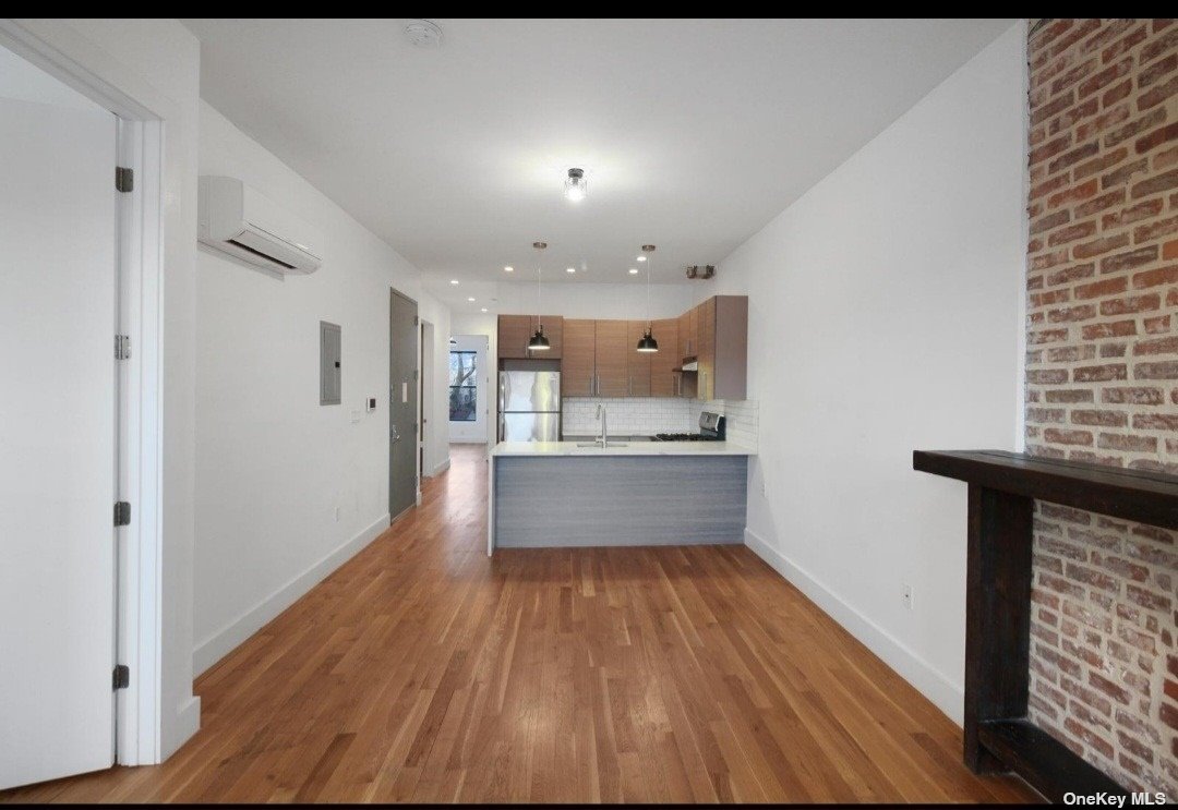 a open kitchen with kitchen island a sink dishwasher a refrigerator and wooden floor