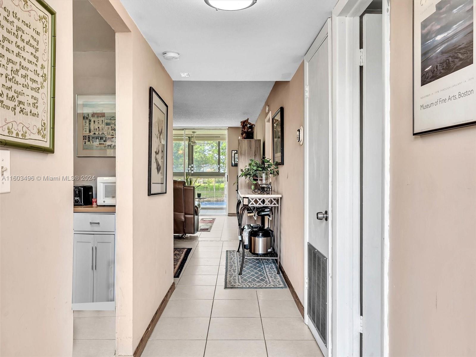 a hallway with white cabinets and chairs