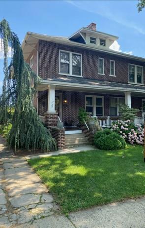 a front view of a house with garden and porch