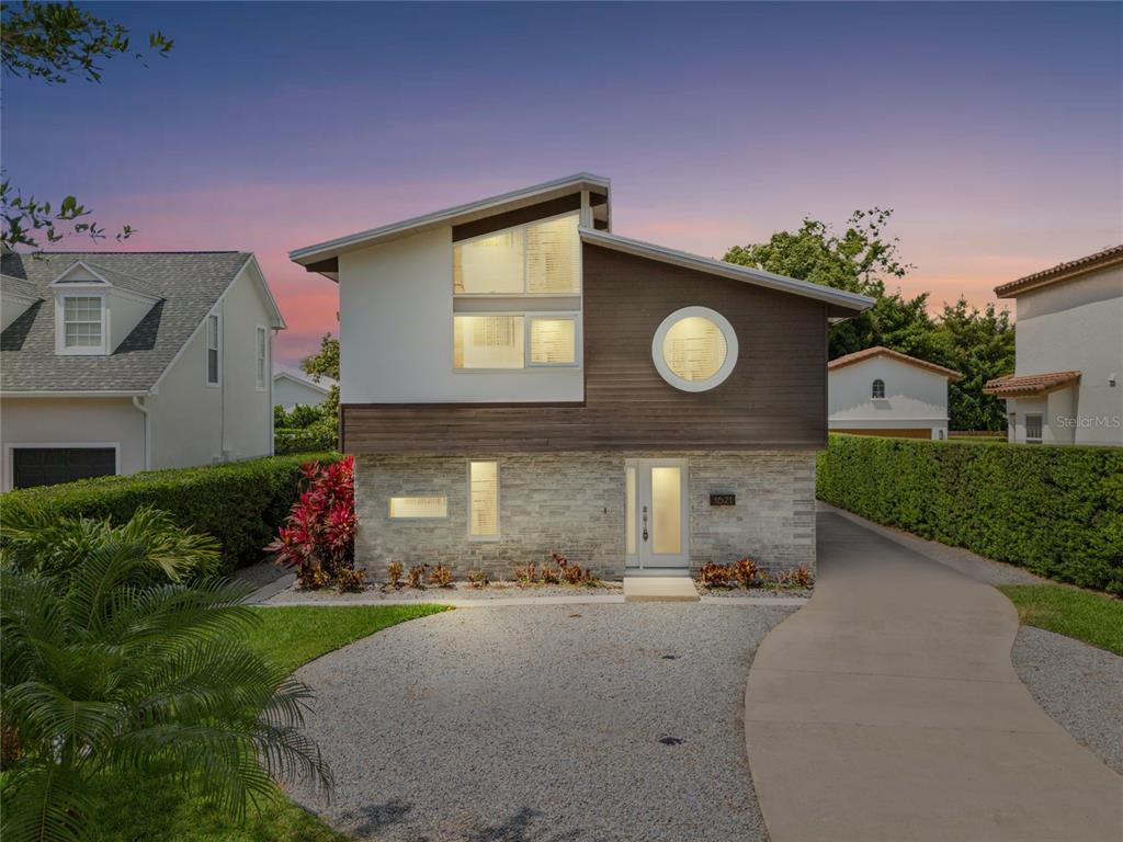 a front view of a house with a yard and a tree