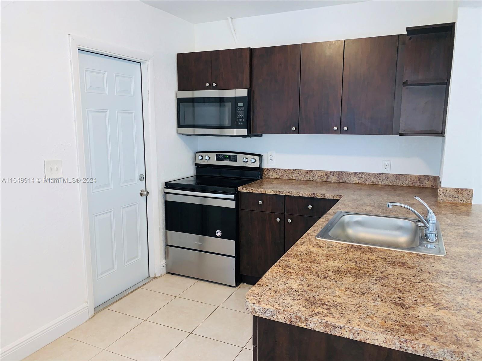 a kitchen with granite countertop a sink and a stove top oven