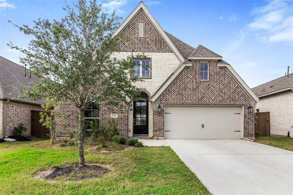 Charming two-story brick home with a pitched roof and double garage. Features a well-maintained front lawn with a tree and a spacious driveway. Ideal for families seeking a modern and inviting living space.