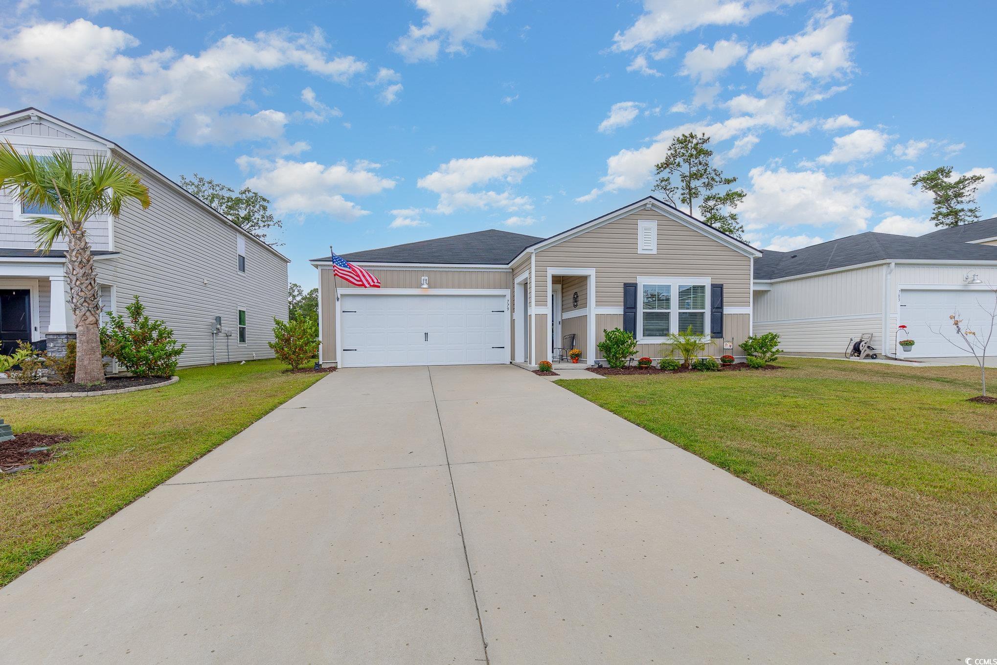 Single story home featuring a front lawn and a gar