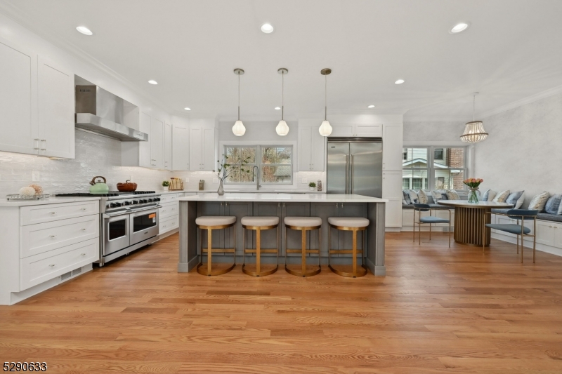 a kitchen with stainless steel appliances granite countertop a stove a sink and a wooden floors