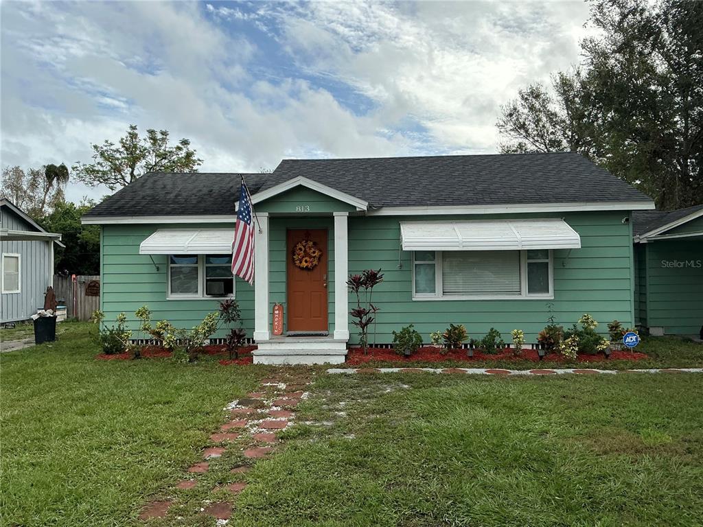 a front view of a house with a garden and plants