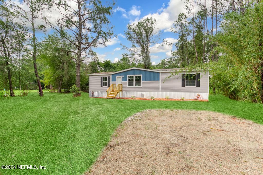 a front view of house with yard and green space