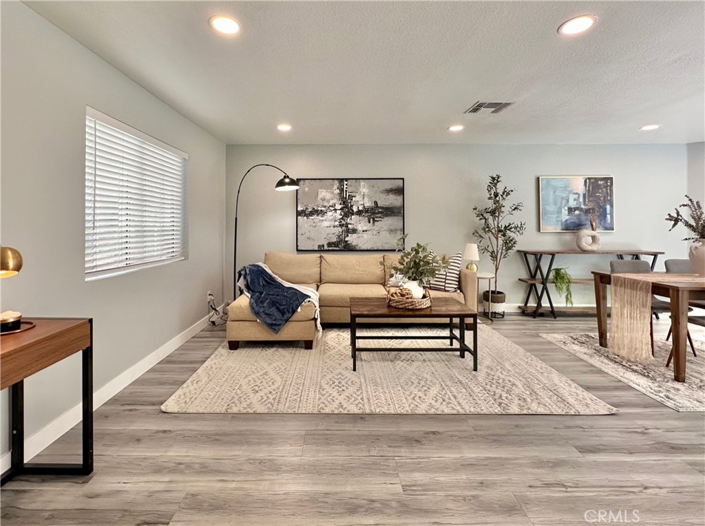 a living room with furniture and a wooden floor