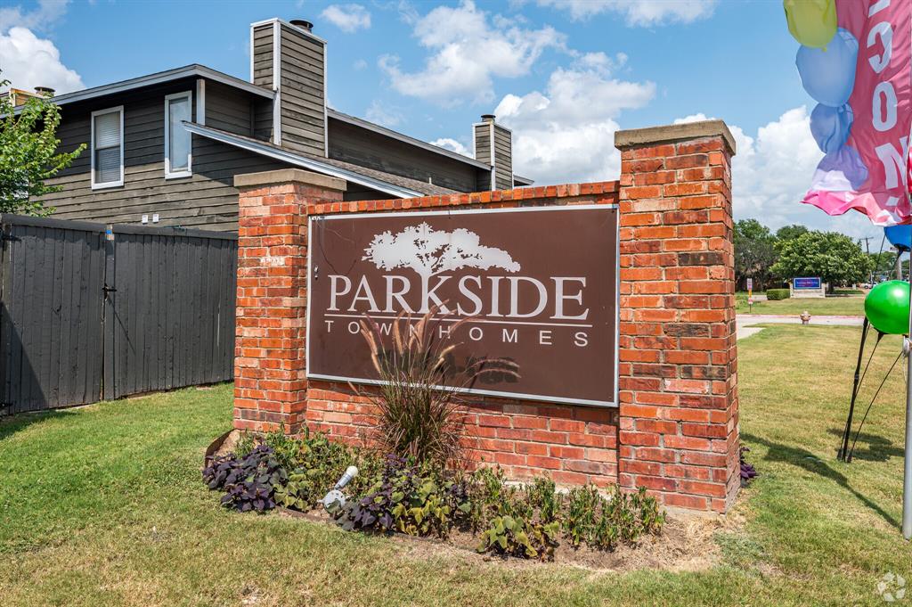 Community / neighborhood sign featuring a yard