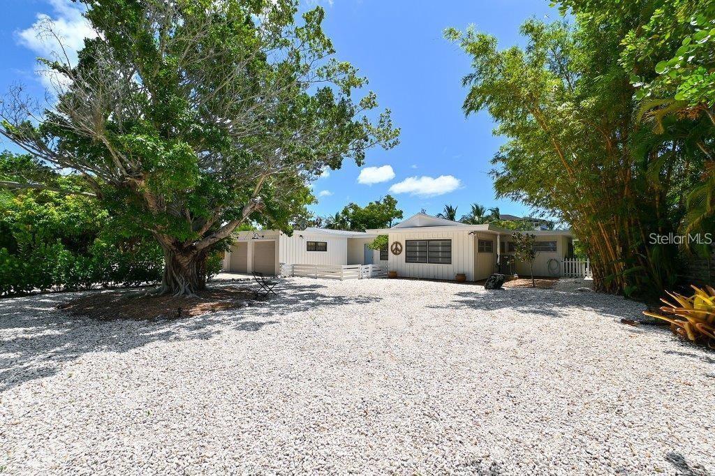 a front view of a house with a yard and trees