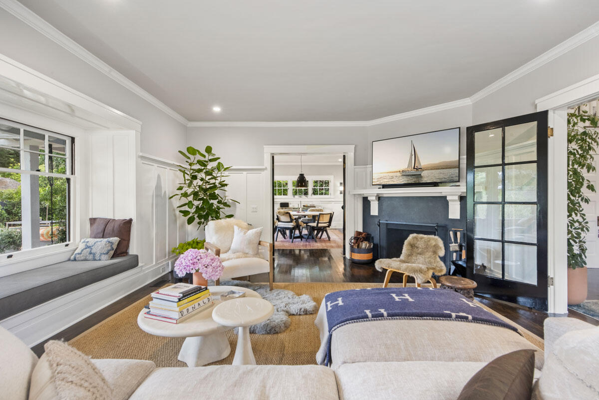 a living room with furniture a fireplace and a floor to ceiling window