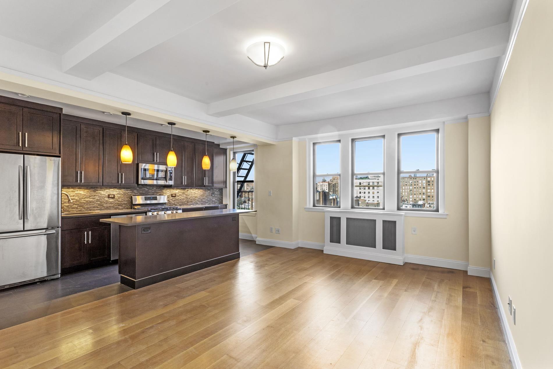 a large kitchen with a large counter top and stainless steel appliances