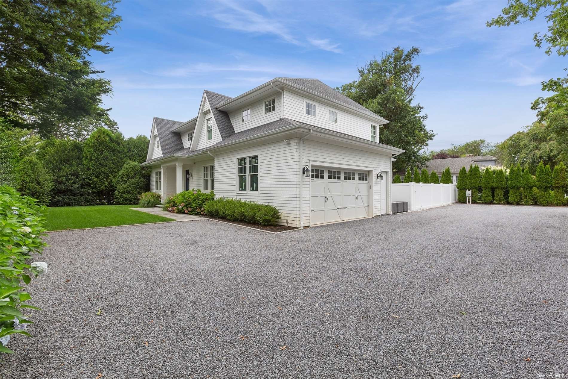 a view of a house with a yard and large tree