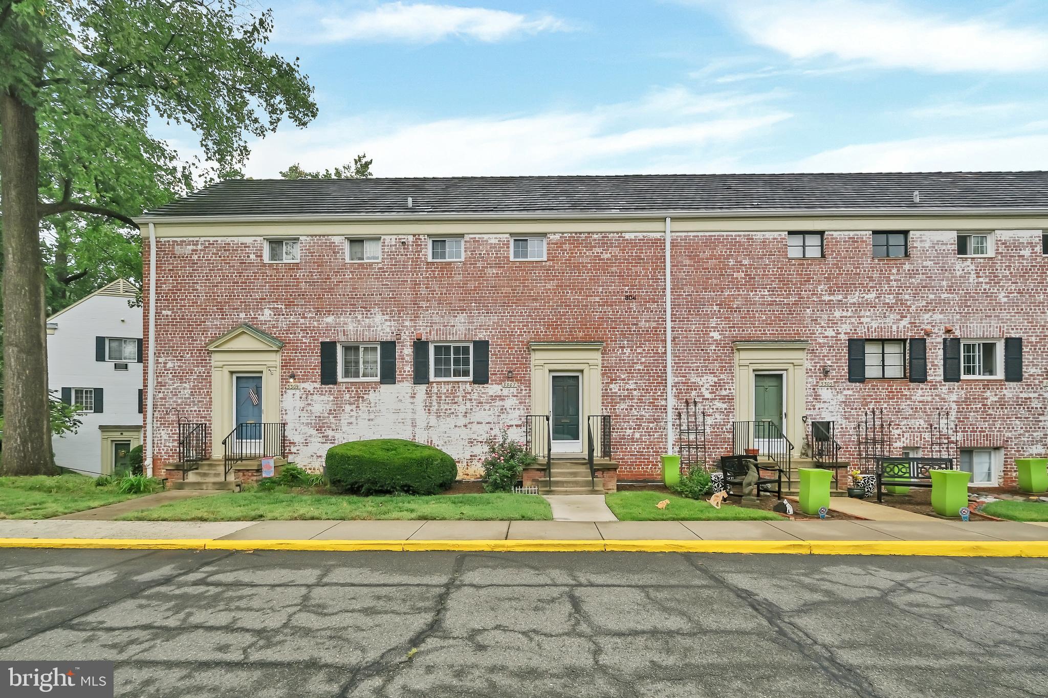 a view of a brick house with a swimming pool and a big yard