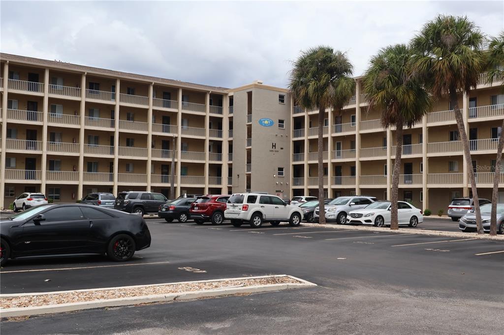 a front view of a building with cars parked