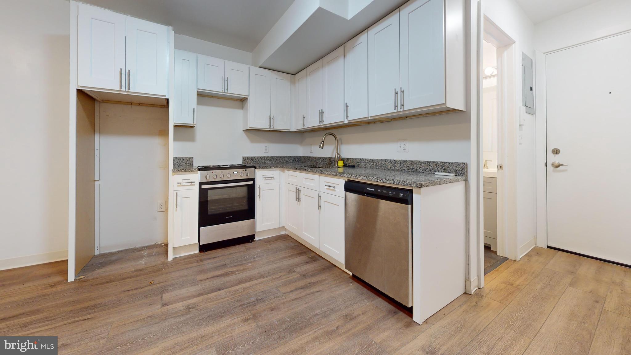 a kitchen with a stove top oven and cabinets