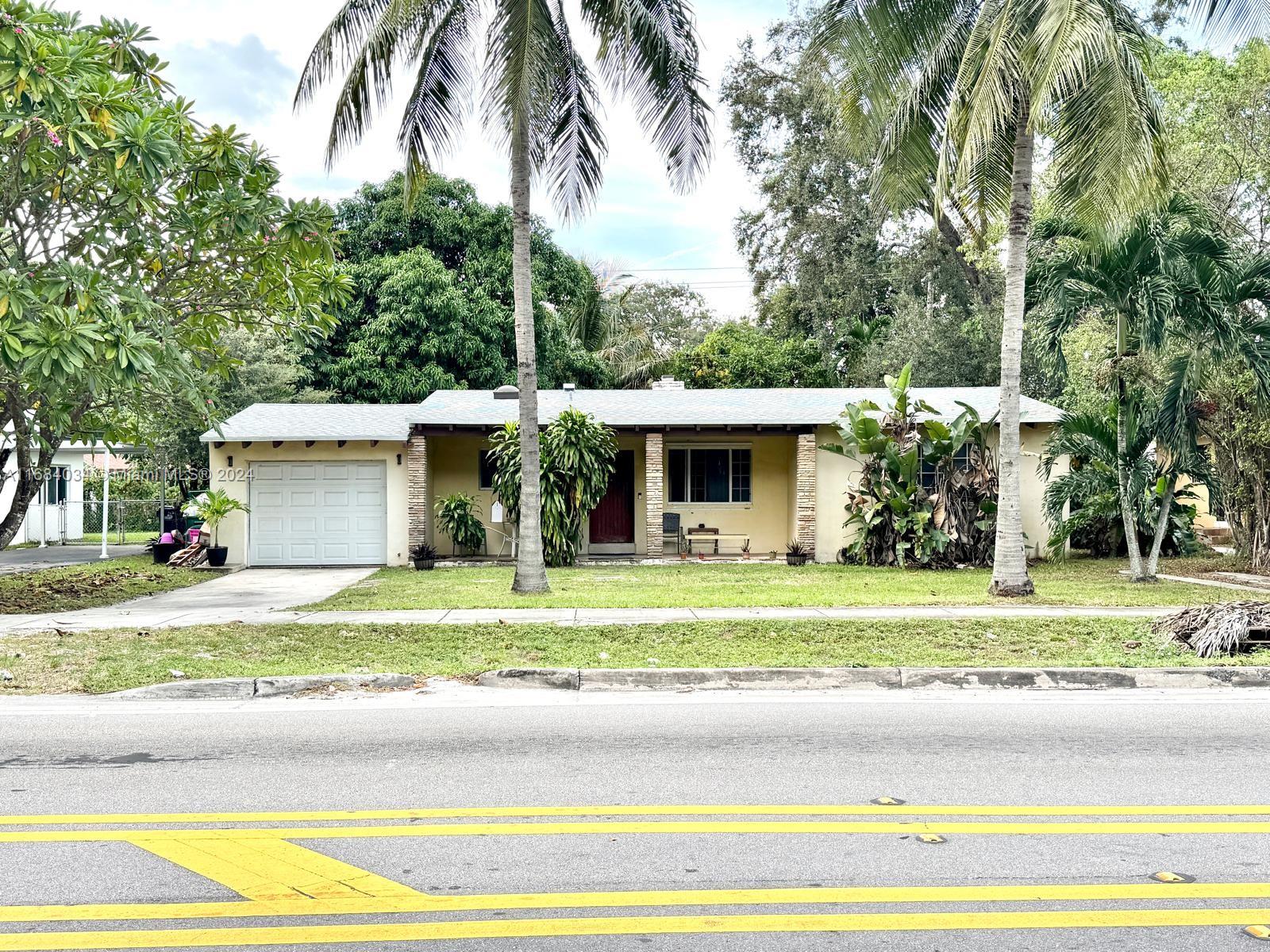 a front view of a house with a garden and trees