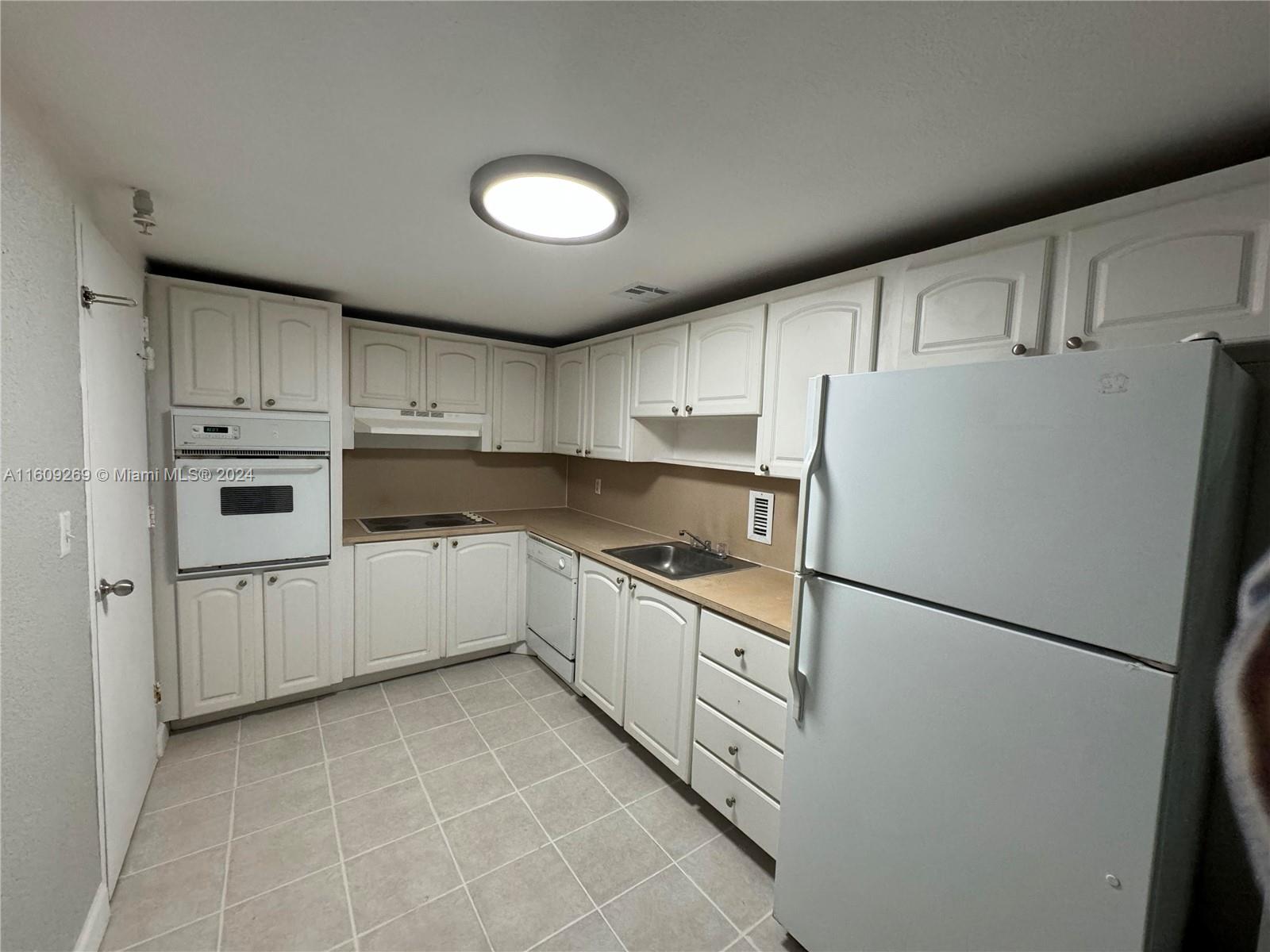 a kitchen with white cabinets and white appliances