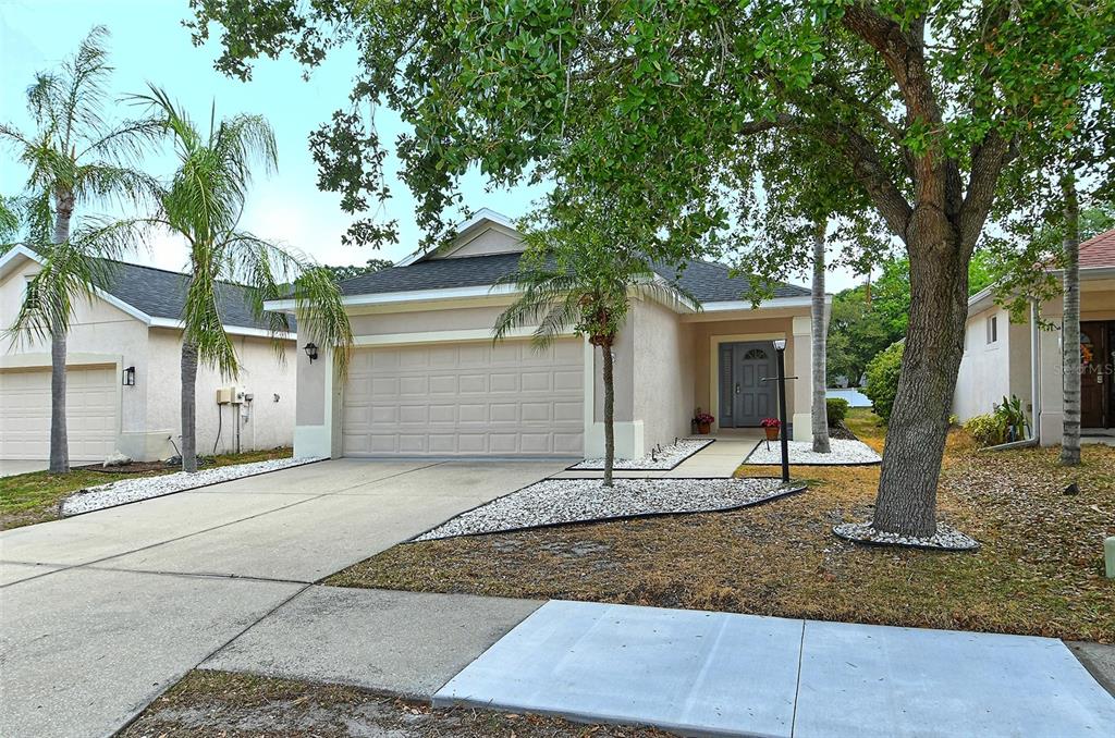 a front view of a house with a tree