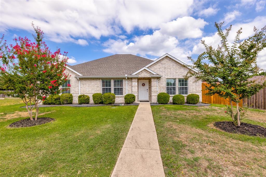 a front view of a house with a yard and trees