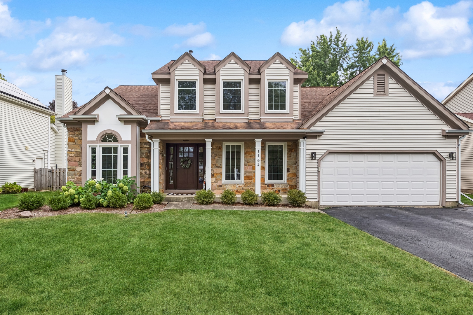 a front view of a house with a garden and yard