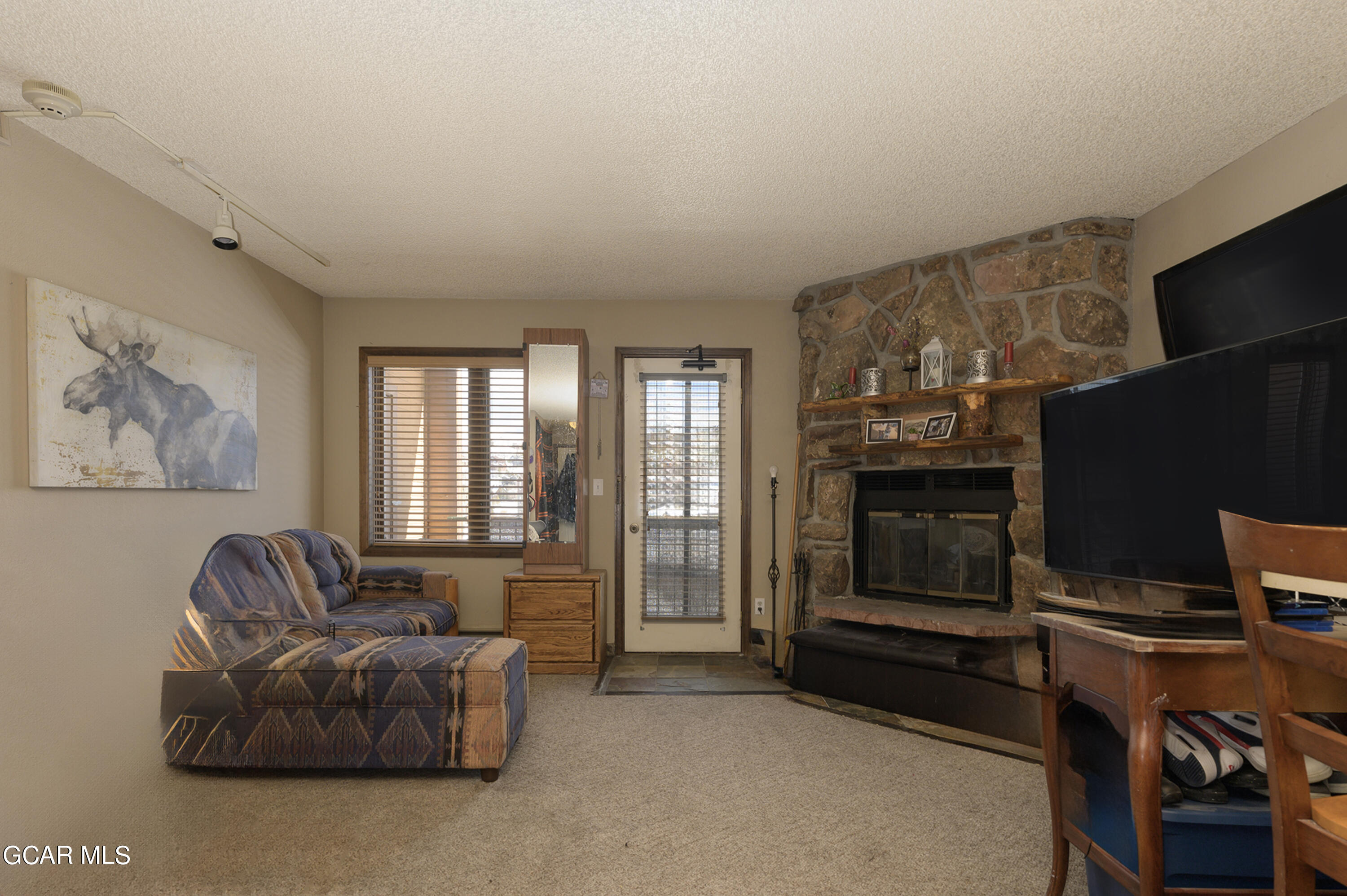 a living room with furniture a flat screen tv and a fireplace