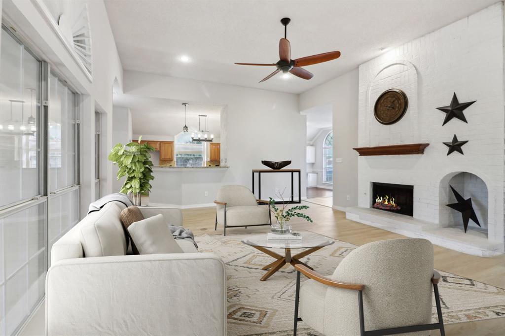 a living room with furniture a fireplace and a large window