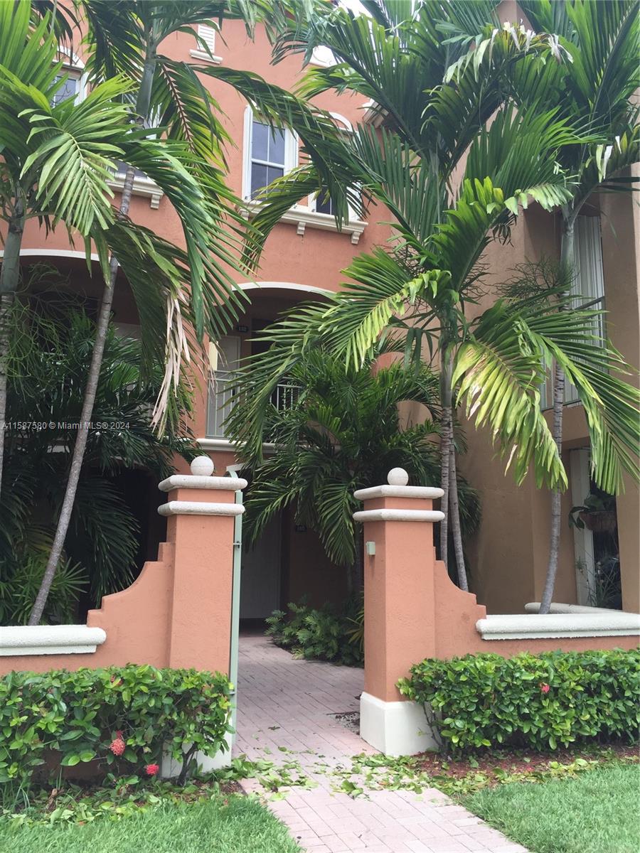 a view of a white house with a yard and potted plants