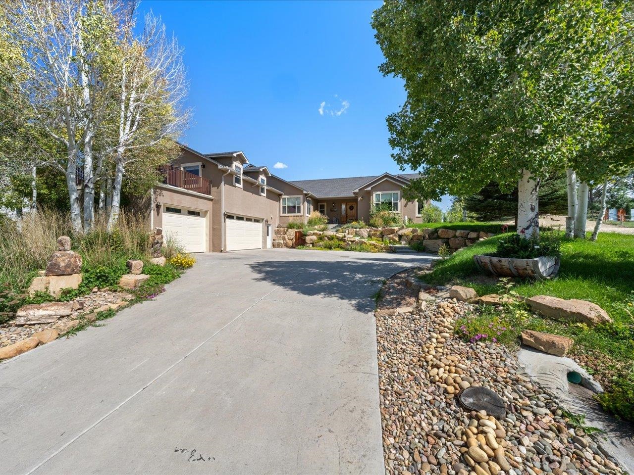 a front view of a house with a yard and lake view