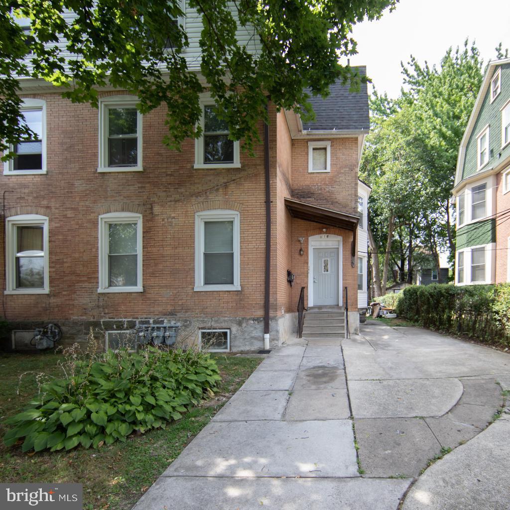 a front view of a house with a yard and trees