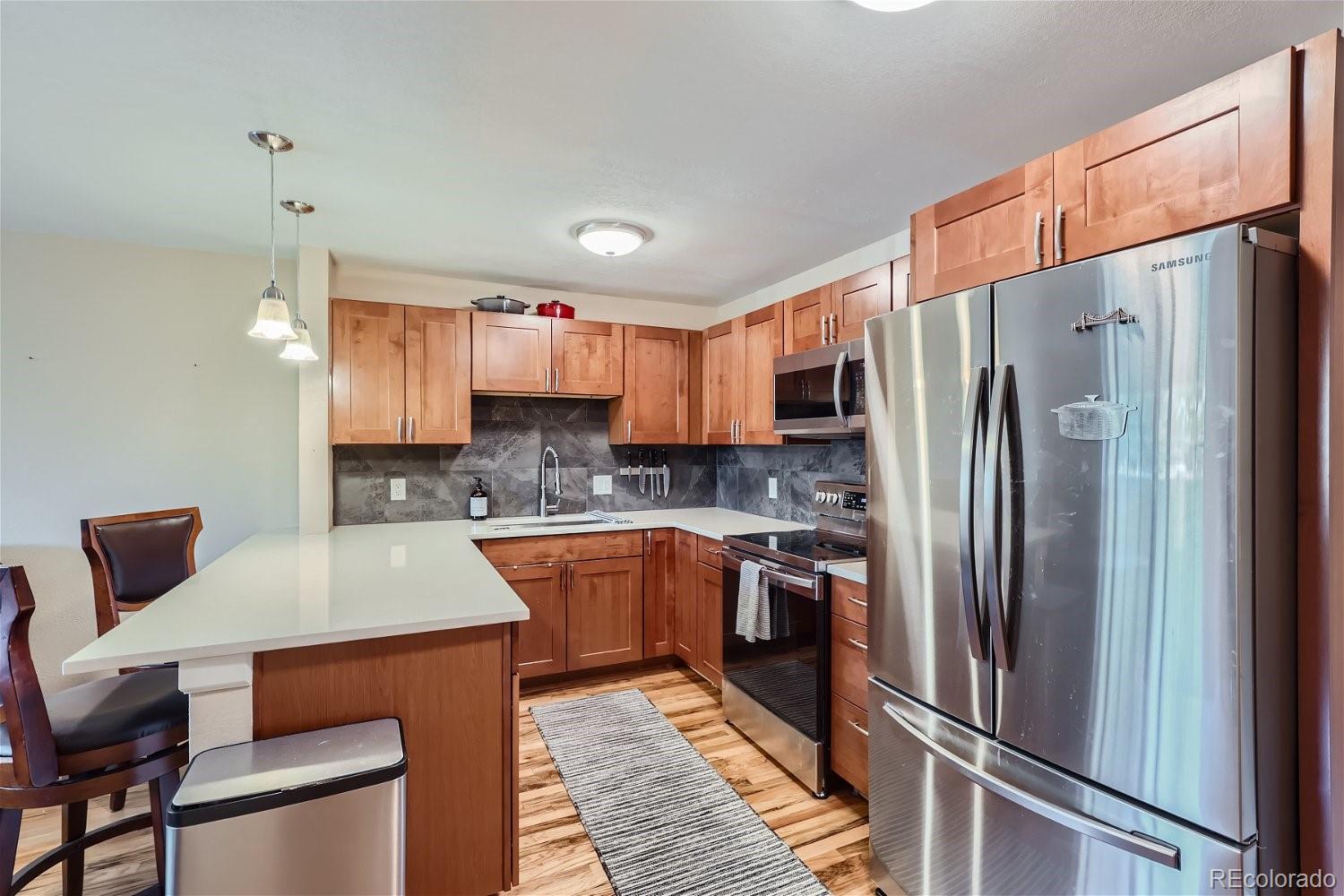 a kitchen with stainless steel appliances a refrigerator sink and microwave