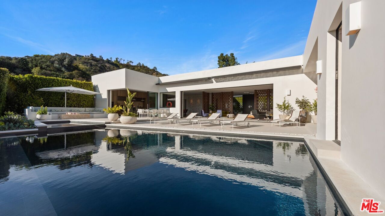 a view of house with swimming pool and a table and chairs in patio