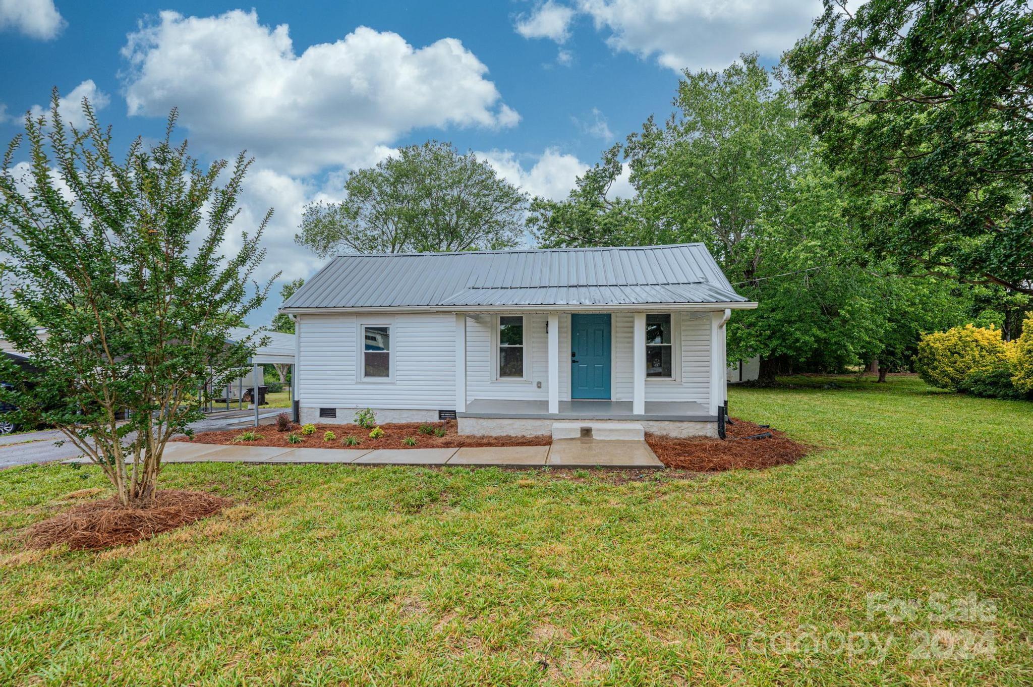 a front view of house with yard and outdoor seating