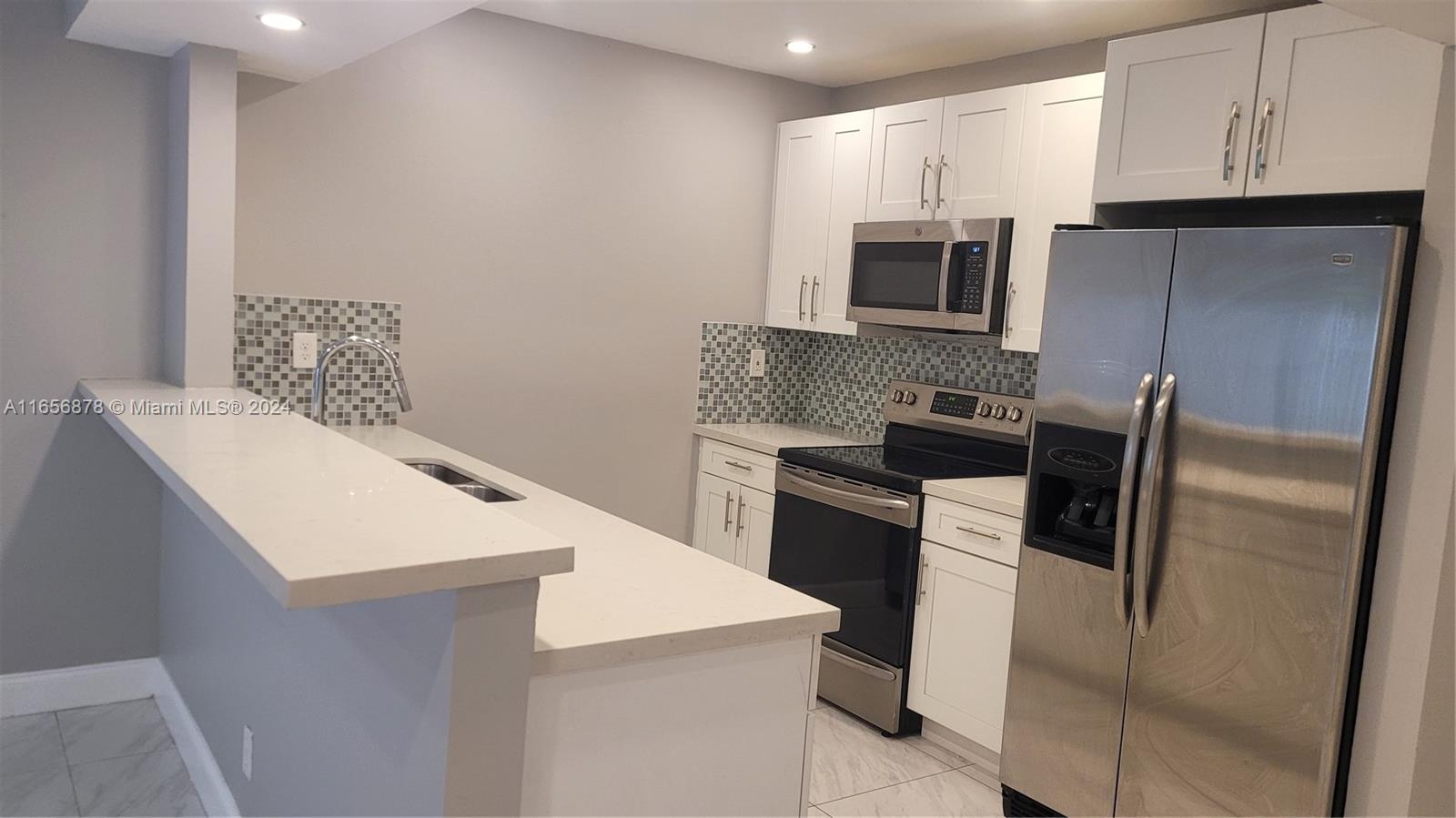 a kitchen with a refrigerator stove and microwave