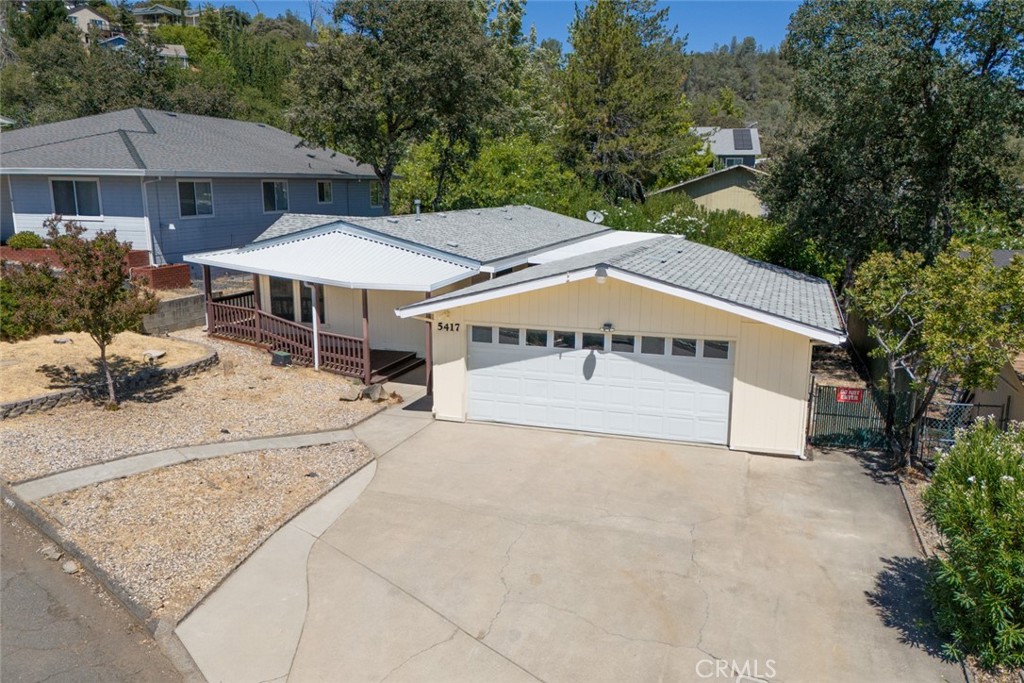 a view of a house with backyard and sitting area