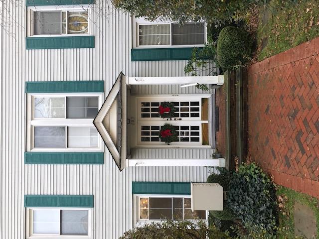 a view of a white house with a large window and a yard