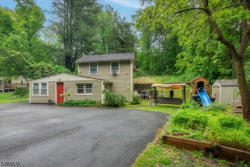 a view of a house with a yard and large trees