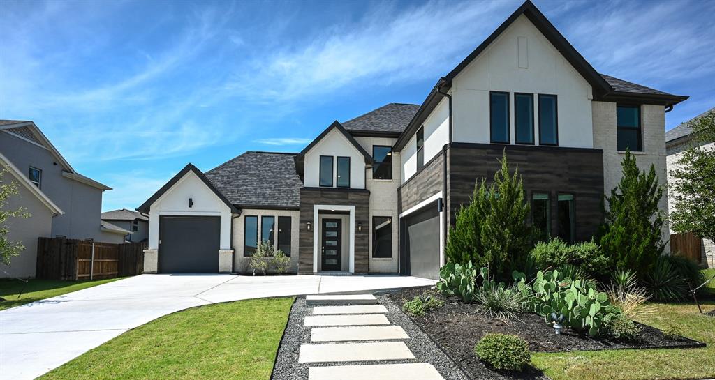 a front view of a house with a yard and trees