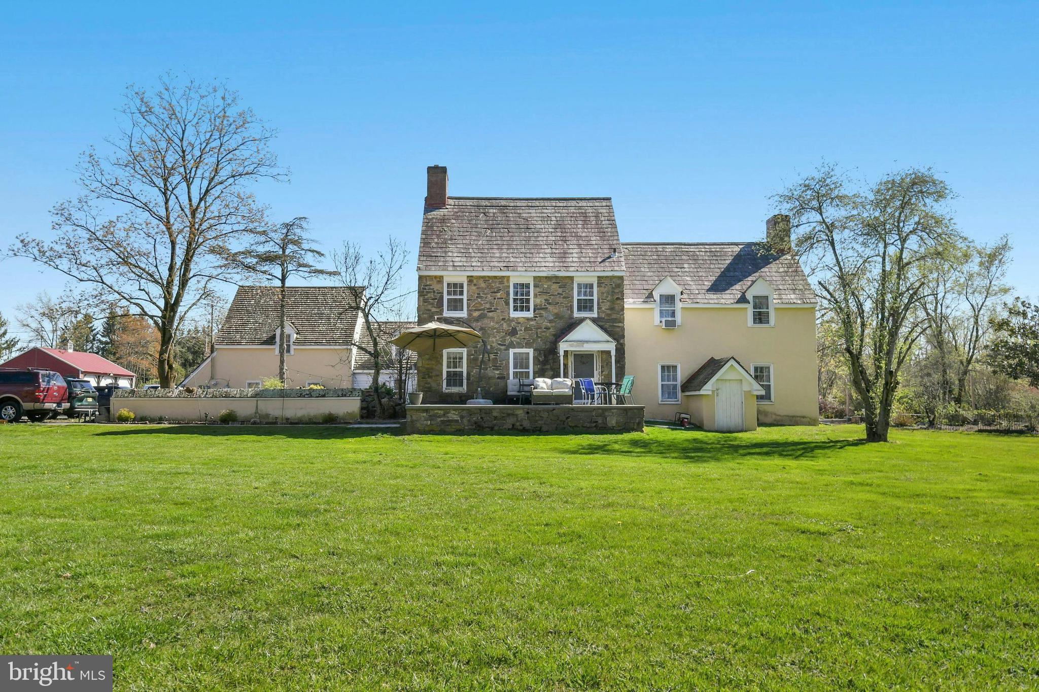 a view of a house with a big yard and large trees