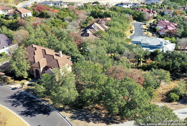 an aerial view of residential house with outdoor space and trees all around