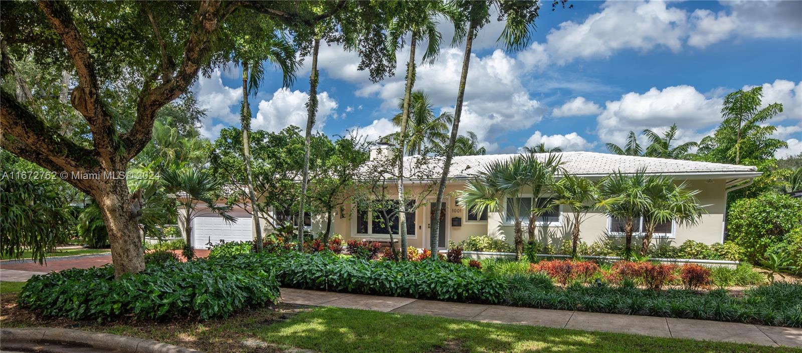 a view of a white house with a yard and potted plants