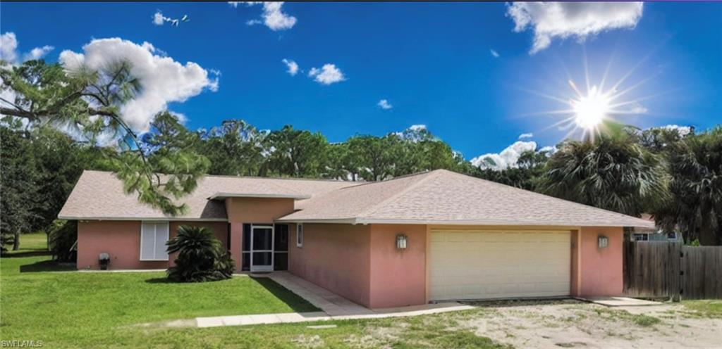 a view of a house with a yard and a garage